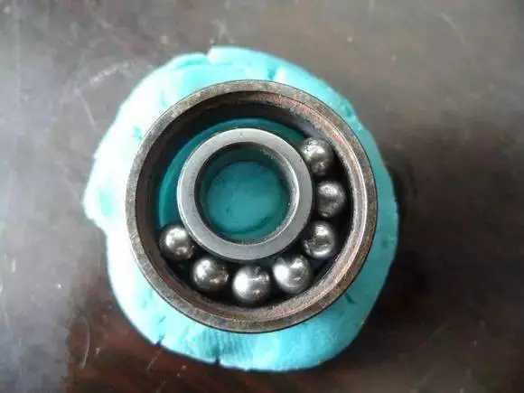 隨后將內圈擠到鋼珠那邊，使鋼珠卡在凹槽中間